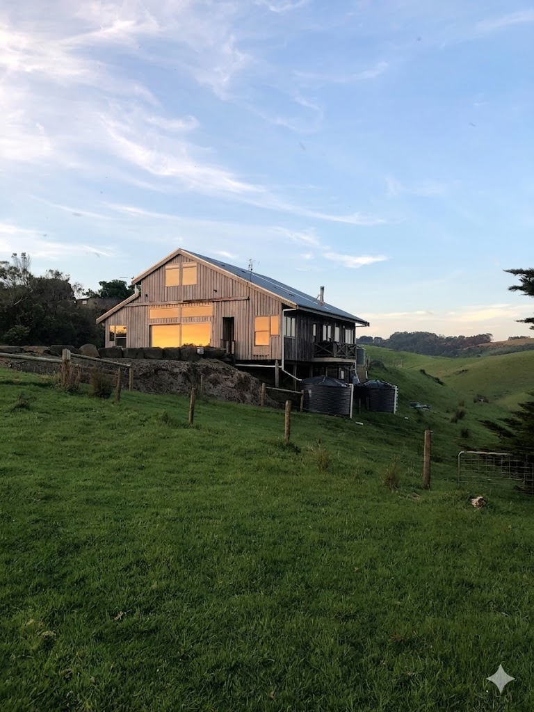 A timber lodge above a green pasture at dusk